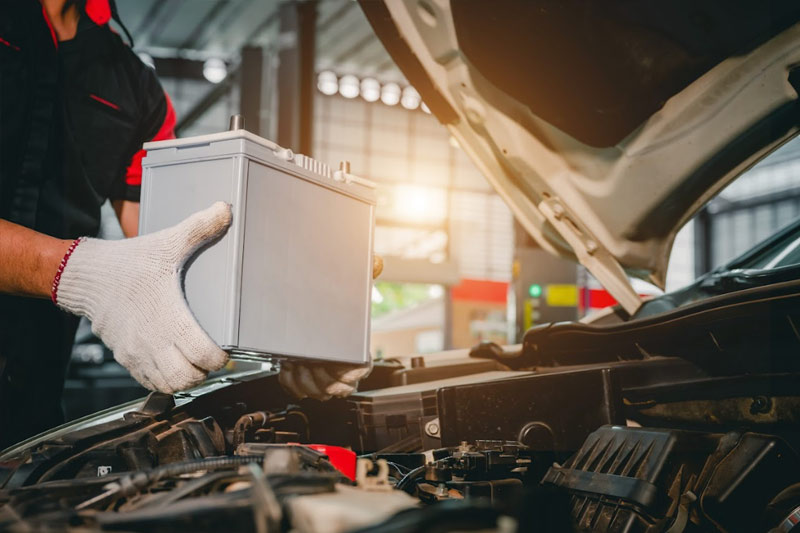 mechanic performing a car battery service replacement