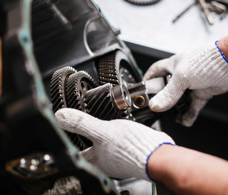 men holding a car transmission during a transmission repair